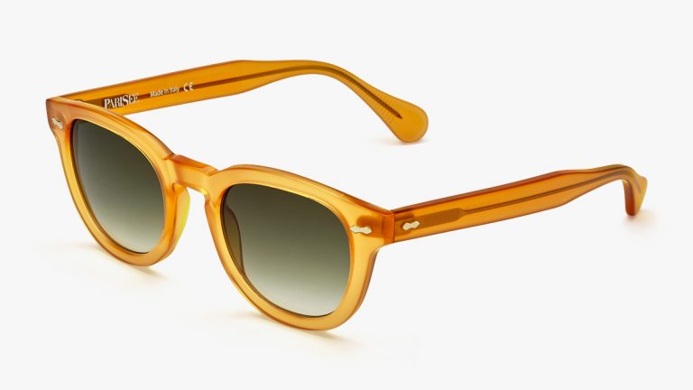 Packshot lunettes solaires trois-quarts — monture acétate ambre translucide, verres dégradés olive